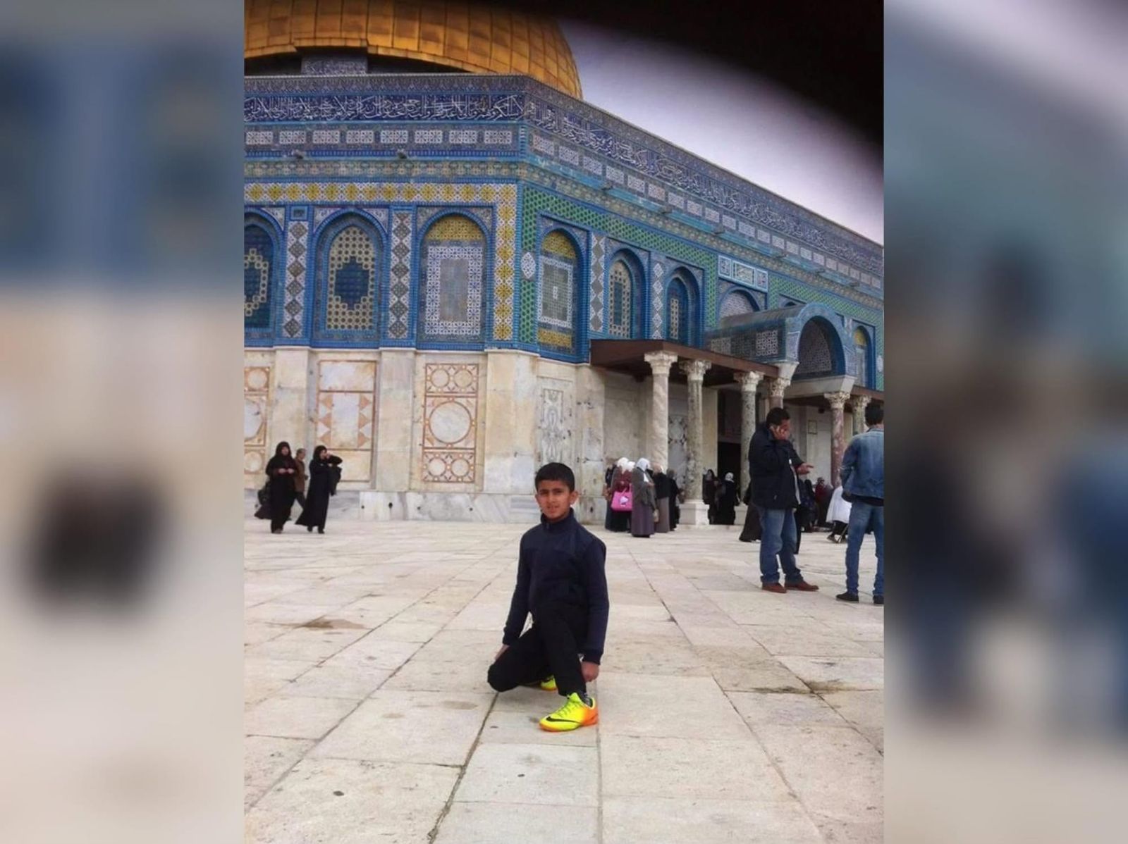 A little boy standing in front of the Dome of the Rock in Jerusalem.